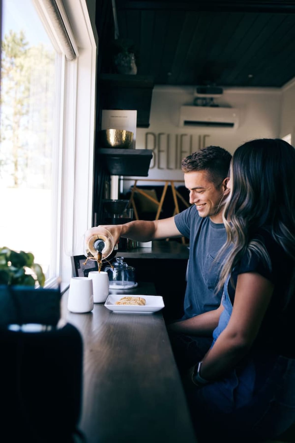 A couple making pour-over coffee in The Lux tiny home