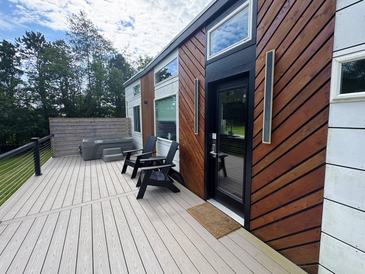 The deck and front door of The Lux tiny home