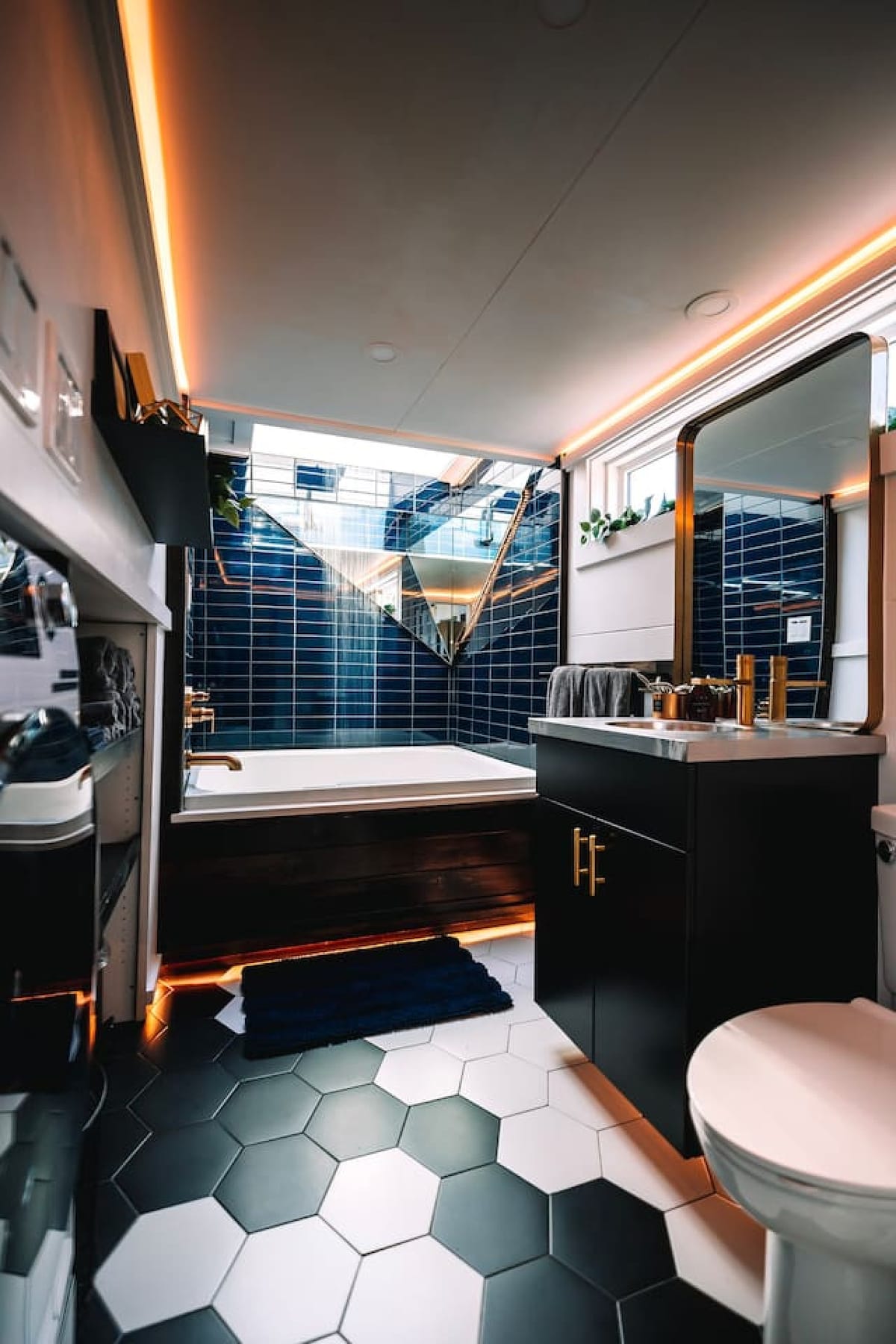 Two-person jacuzzi tub with navy tile and a skylight inside The Lux tiny home in Berlin, Ohio