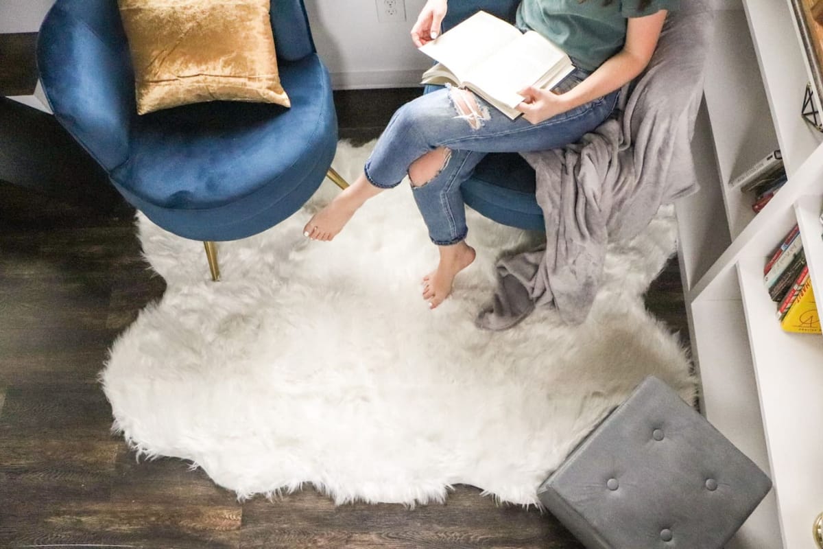 A guest reading in a blue velvet chair inside The Lux