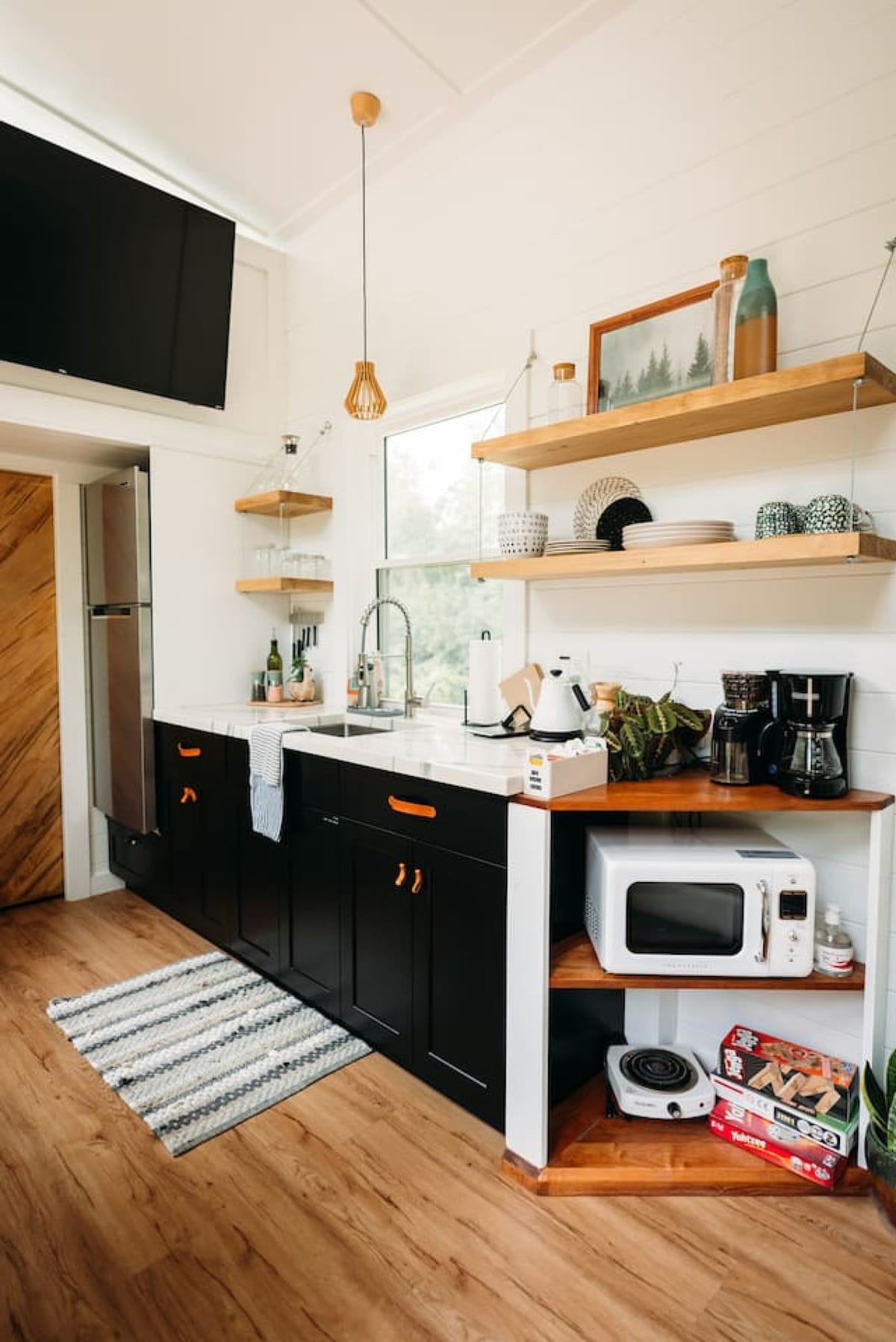 The Scandi kitchenette with oak shelves, coffee station, and full-size fridge